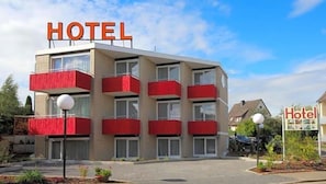 A hotel building with multiple balconies, a clear sky, and a sign indicating the hotel's name. - Hotel Deisterblick (Bad Nenndorf)