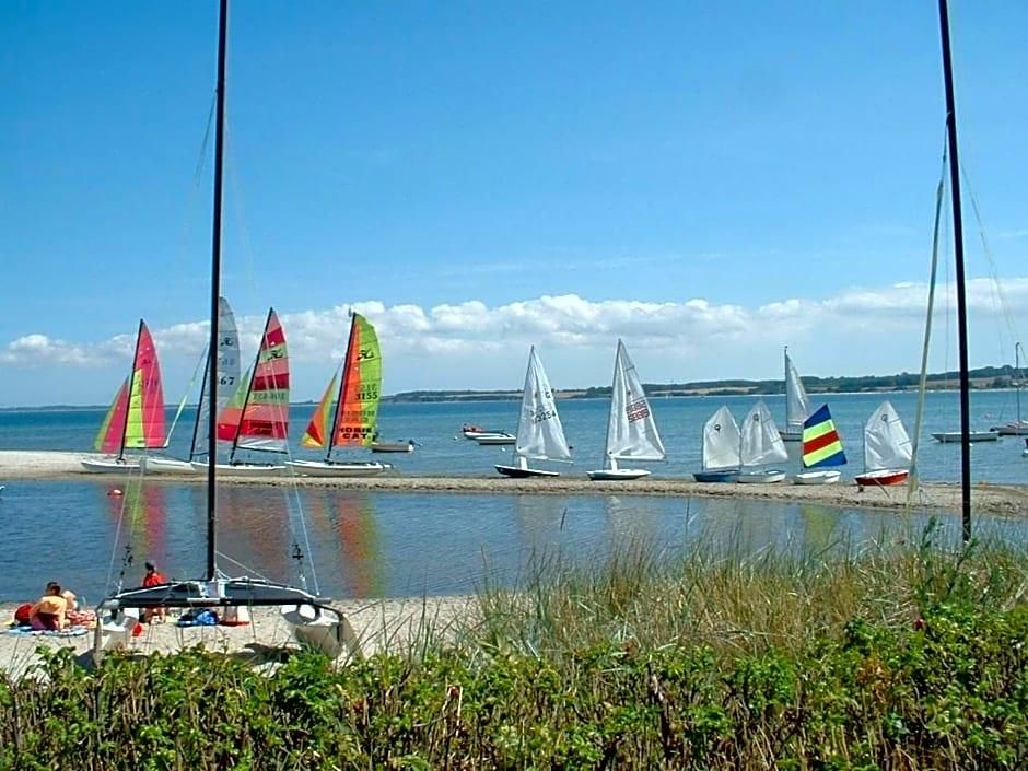 A beach with sailboats and a sandy shore.