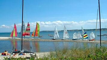 Ein Strand mit Segelbooten und einem sandigen Ufer.