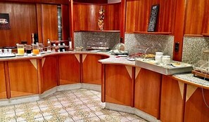Ein Frühstücksbuffet mit einer Auswahl an Speisen und Getränken, Holzvertäfelung und einem gefliesten Boden.