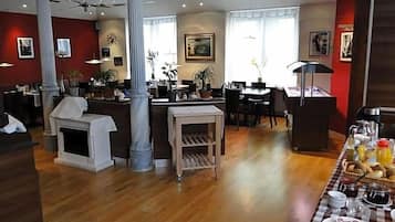 Een hotel lobby met een eetgedeelte, een open haard en een ontbijtbuffet.