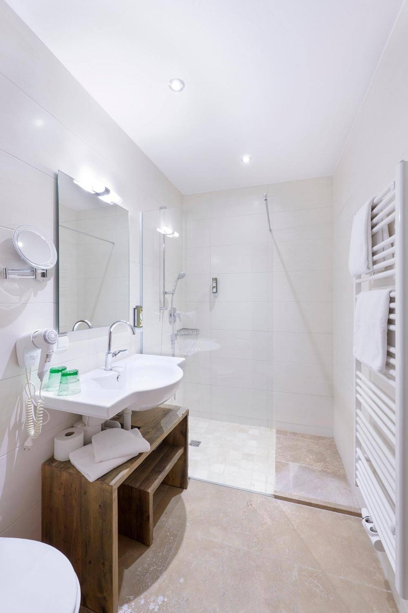 Un baño moderno con lavamanos doble, espejo, ducha y toallero.