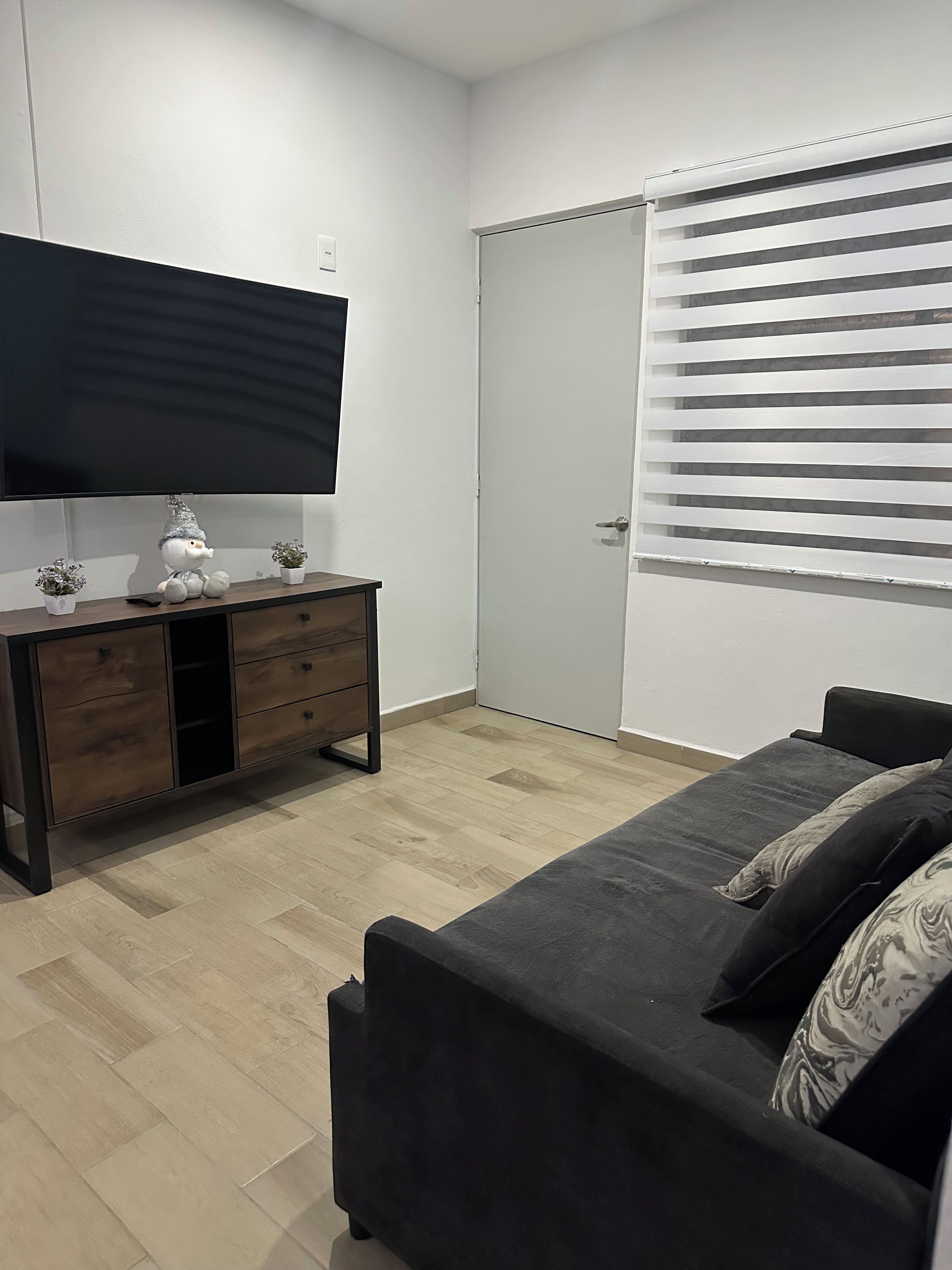 A bedroom with a bed, a dresser, a television, and a closet.