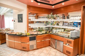 A buffet setup with a variety of food items, glassware, and condiments. - Anabel (Valle Aurina)