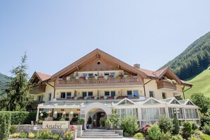 A hotel with a traditional Alpine architectural style, featuring a prominent balcony with flower boxes and a clear view of the surrounding mountainous landscape. - Anabel (Valle Aurina)