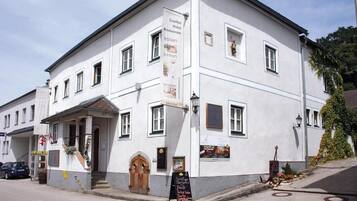 Ein weißes Gebäude mit einem Schild, das ein Hotel und ein Restaurant bewirbt.