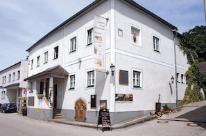 Ein weißes Gebäude mit einem Schild, das ein Hotel und ein Restaurant bewirbt.