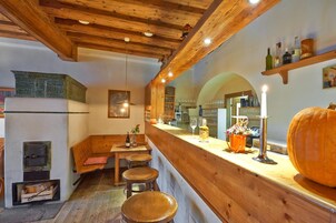 Un rincón acogedor de bar con vigas de madera, mostrador de madera, taburetes y una decoración con calabaza.