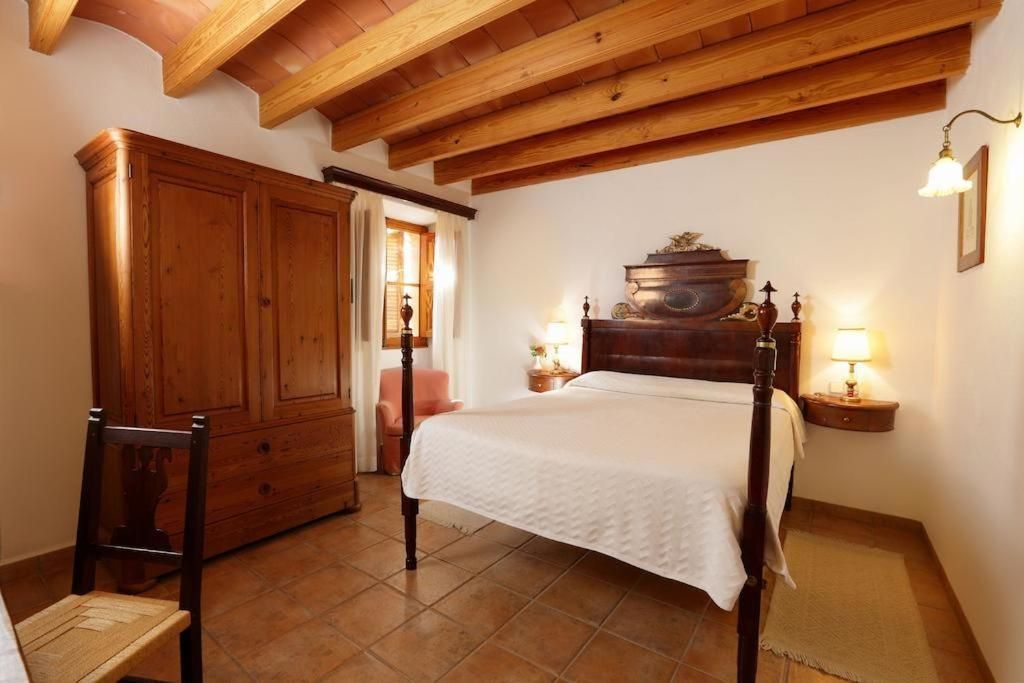 Un dormitorio con cama de madera, un armario y una silla.