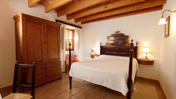 Un dormitorio con cama de madera, un armario y una silla.