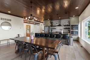 A modern kitchen with a central island, pendant lighting, and a view to the outside. - NEW Bigfoot Views | Sleeps 18 • Games • Playground (Broken Bow)