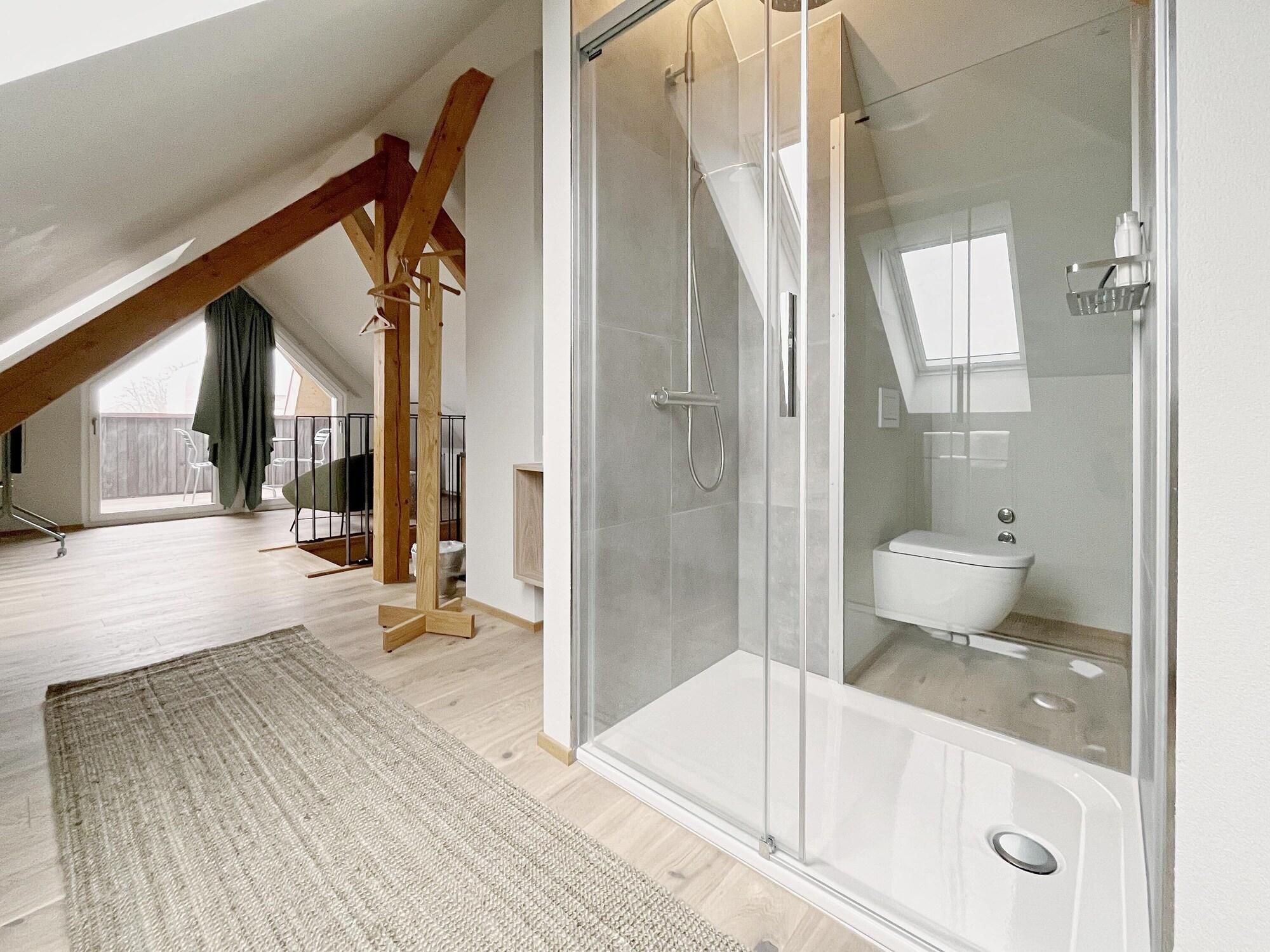 Ein modernes Badezimmer mit Duschkabine aus Glas, Toilette und Badewanne.