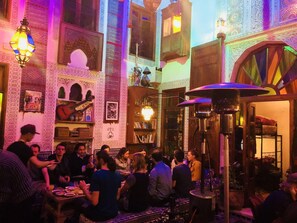 A crowded indoor space with ornate architectural details, including arches and patterned walls. - Riad Verus (Fes)