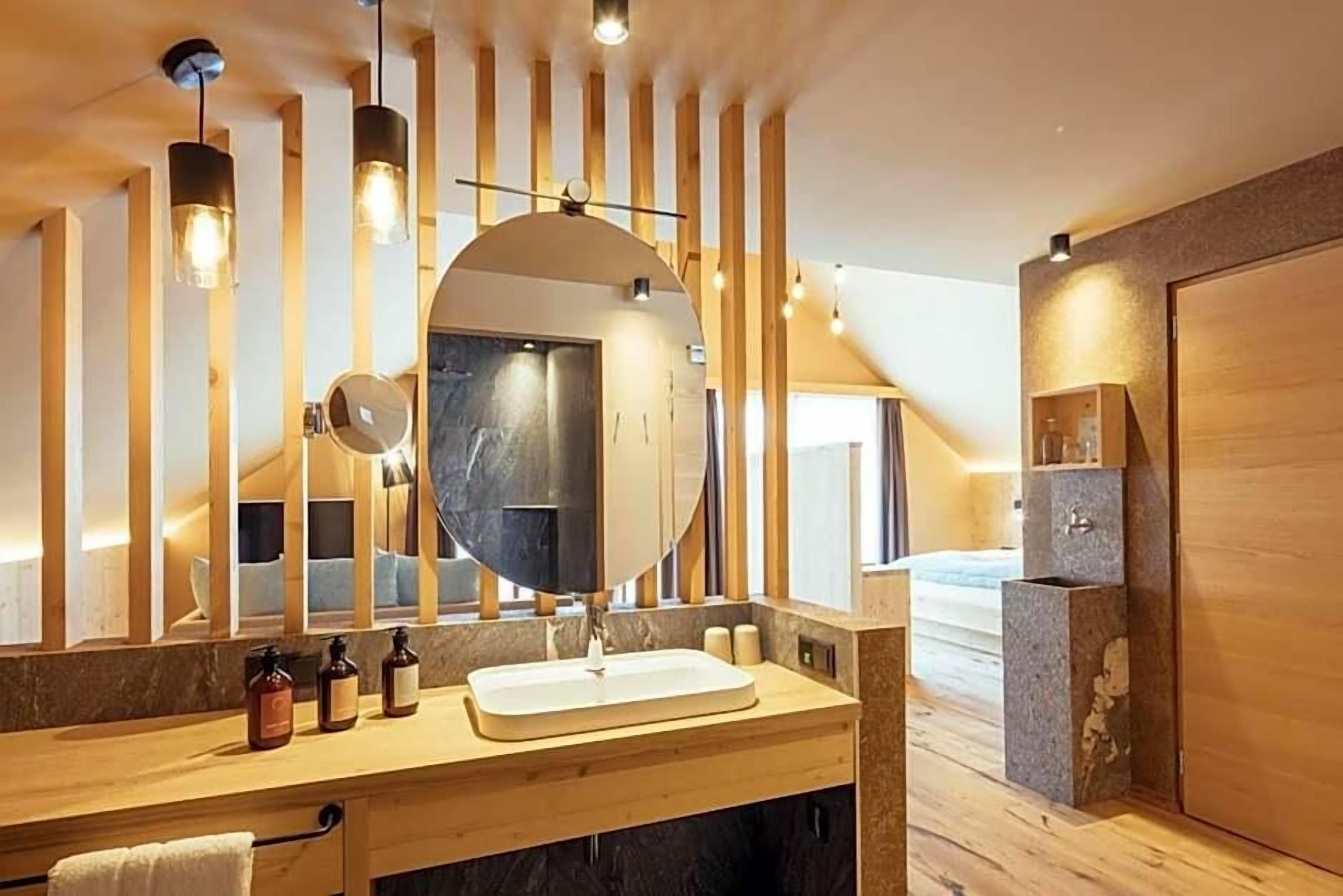 A modern bathroom with a wooden vanity, a large mirror, and a built-in shower area.
