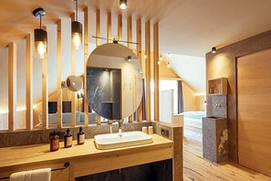 A modern bathroom with a wooden vanity, a large mirror, and a built-in shower area. - Tiroler Hof (San Leonardo in Passiria)