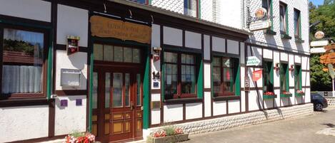 A traditional half-timbered building with a sign for a restaurant and a beer garden.