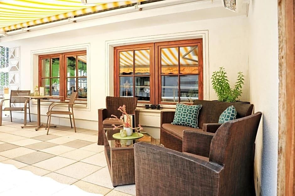 An outdoor seating area with a sofa, chairs, and a small table.