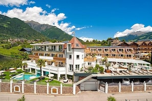A hotel with multiple buildings, a swimming pool, and a mountainous backdrop. - Gnaid (Tirolo)