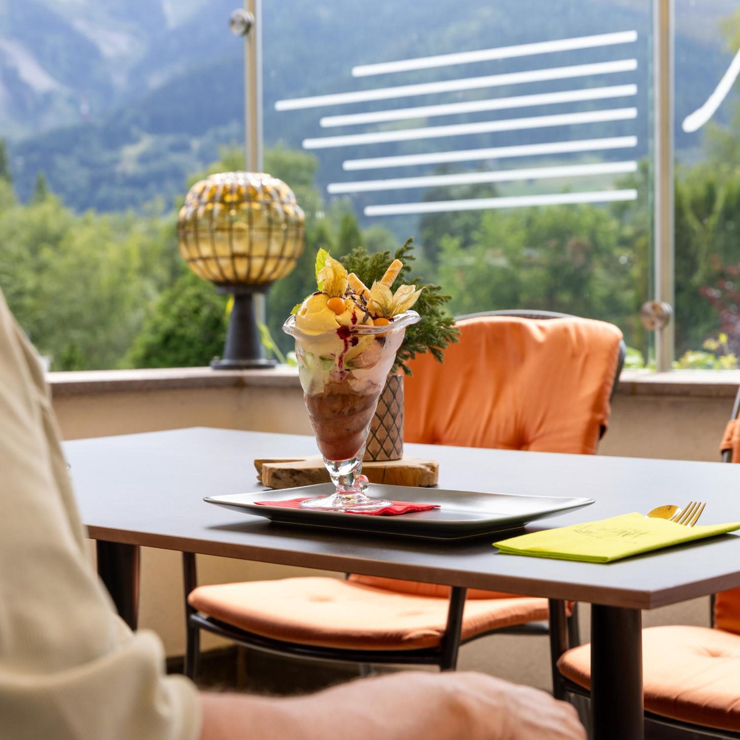 Ein Dessert auf einem Tisch mit Blick auf Berge durch ein Fenster.