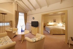 A hotel room with a bed, a television, a desk, and a chair. - Kastanienhof (Bad Muender am Deister)