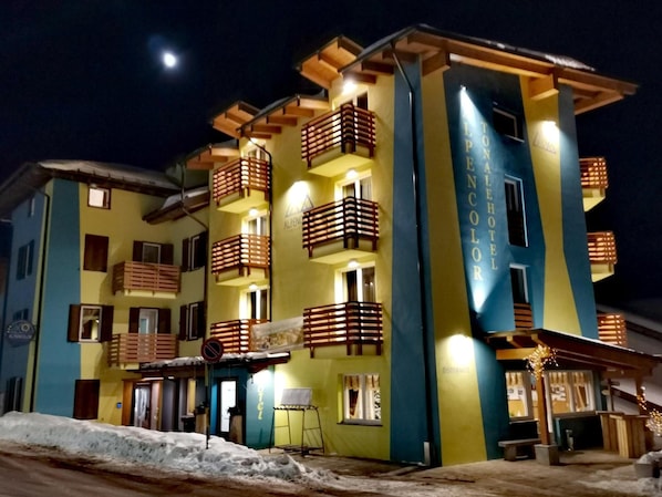A multi-story hotel with balconies, a restaurant, and a sign indicating it's a hotel.