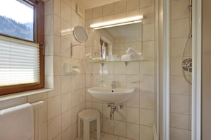 A bathroom with a sink, mirror, and shower. - Waldheim (Mayrhofen)