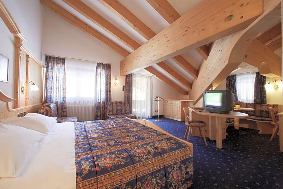 Une chambre d’hôtel avec un grand lit, une télévision, un bureau et une chaise.