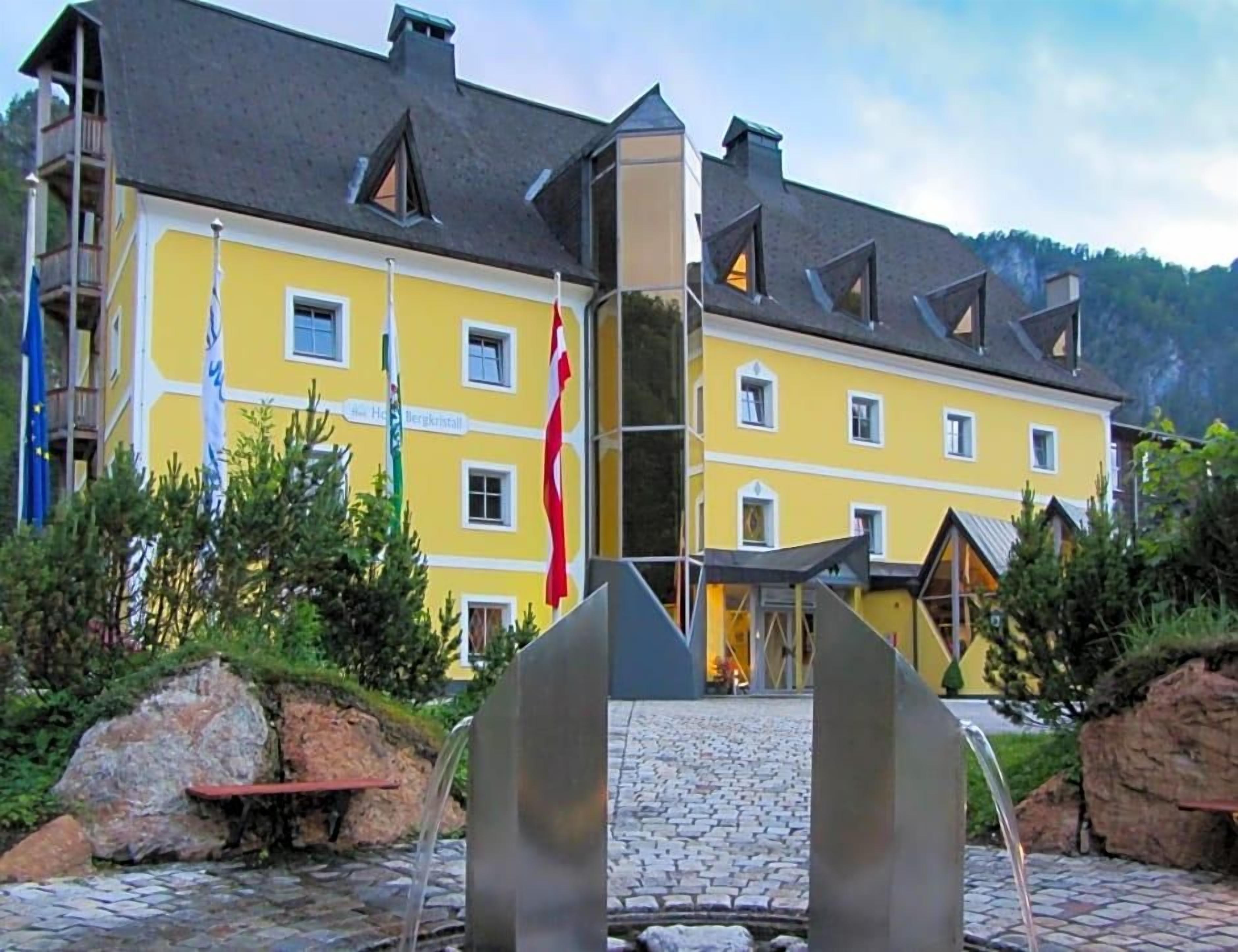 A yellow building with multiple windows and a flagpole.