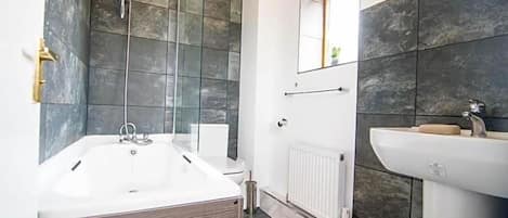 A modern bathroom with a freestanding bathtub, a toilet, and a sink.