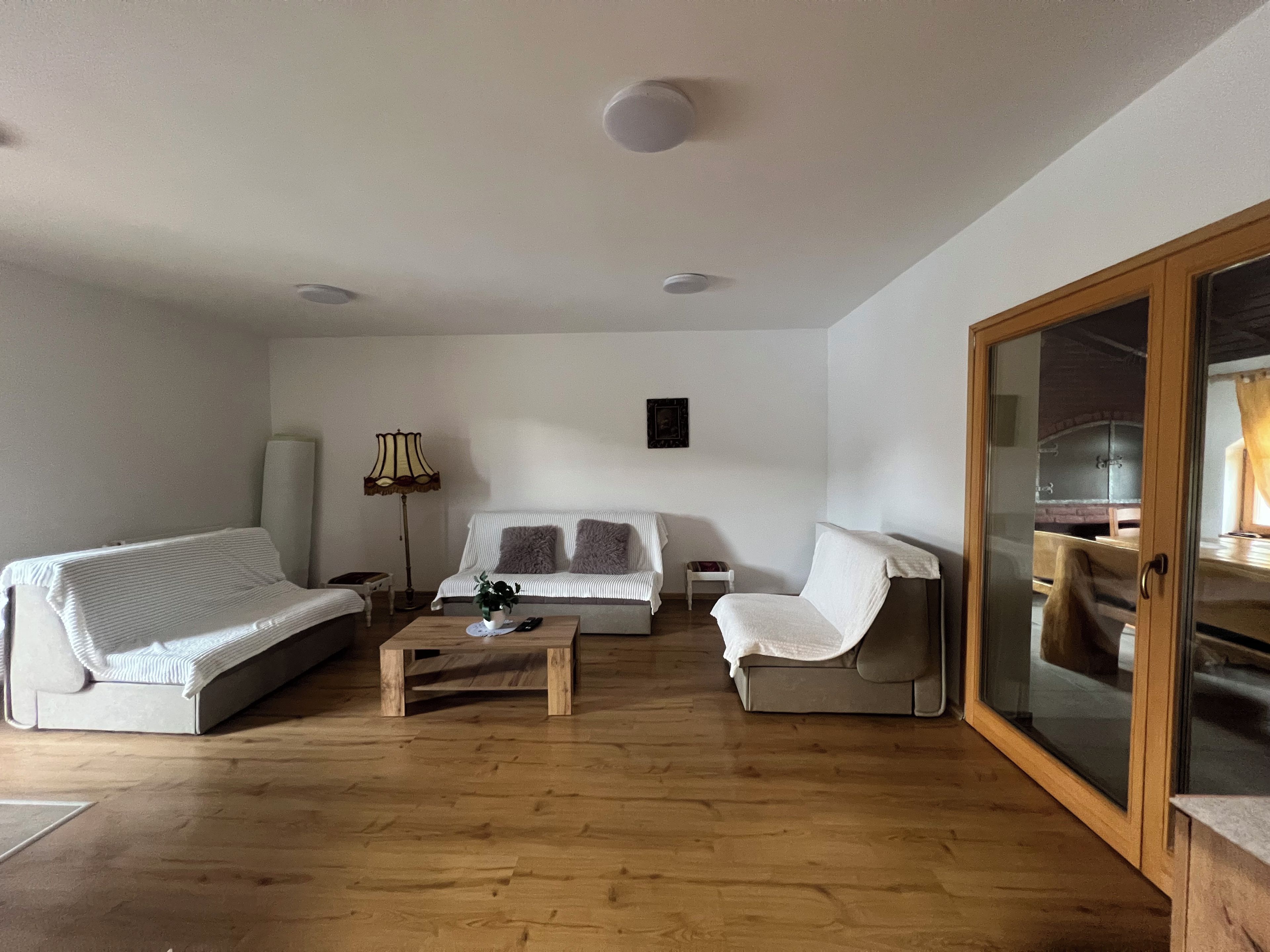 Een woonkamer met een bank, een stoel, een salontafel en een lamp.