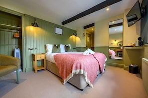 Un dormitorio con cama, mesitas de noche, un espejo y un radiador.