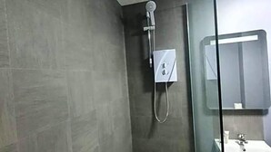 A modern bathroom with a glass shower enclosure, a white sink, and a mirror. - Harleys Inn (Chesterfield)