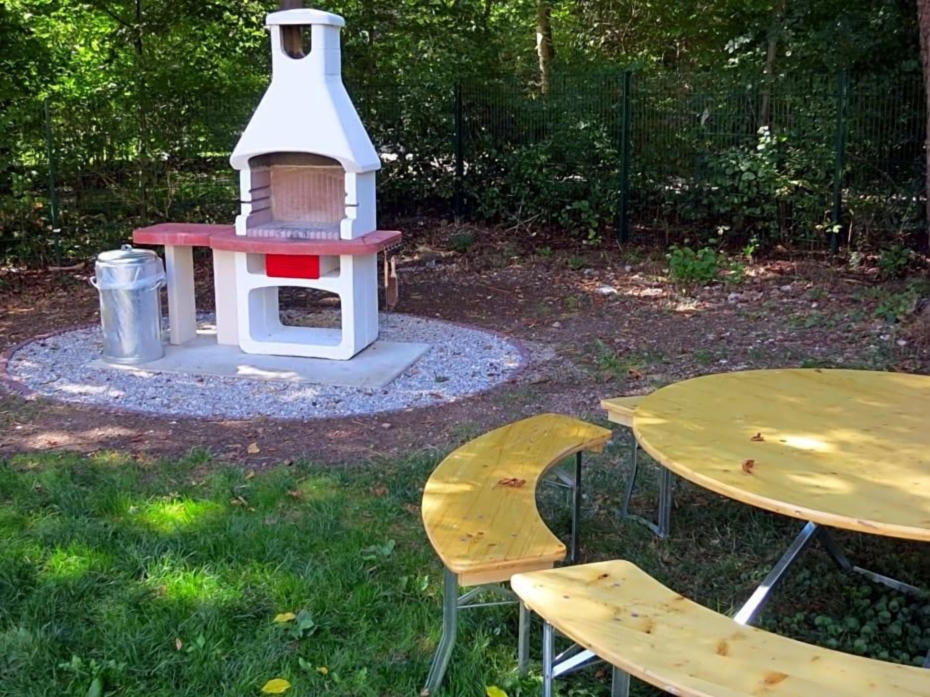 An outdoor seating area with a pizza oven, tables, and chairs.