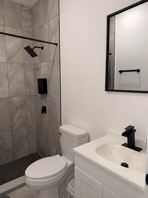 Ein modernes Badezimmer mit Toilette, Waschbecken und Dusche.