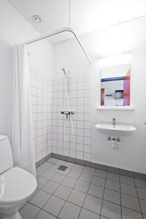 Ein kleines, modernes Badezimmer mit Dusche, Toilette und Waschbecken.