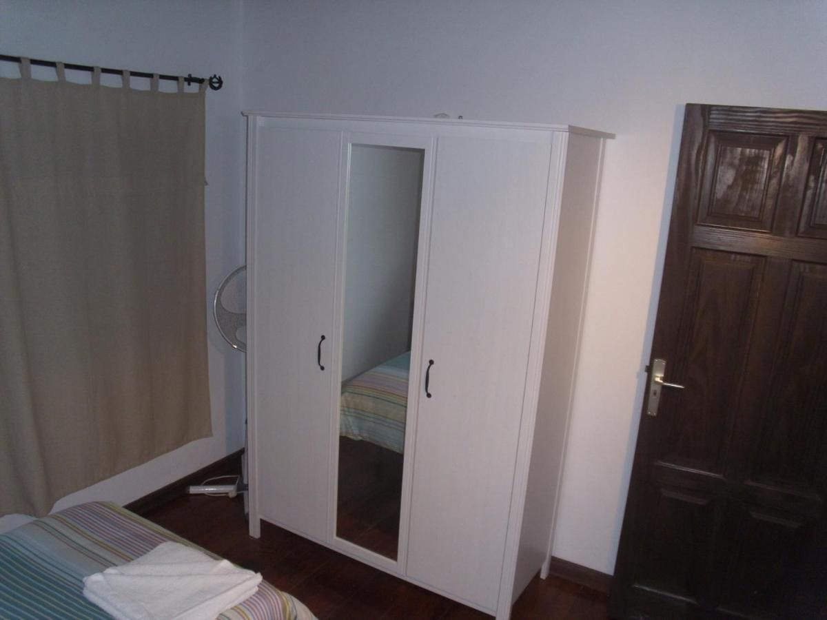 A bedroom with a bed, a wardrobe, a door, and a curtain.
