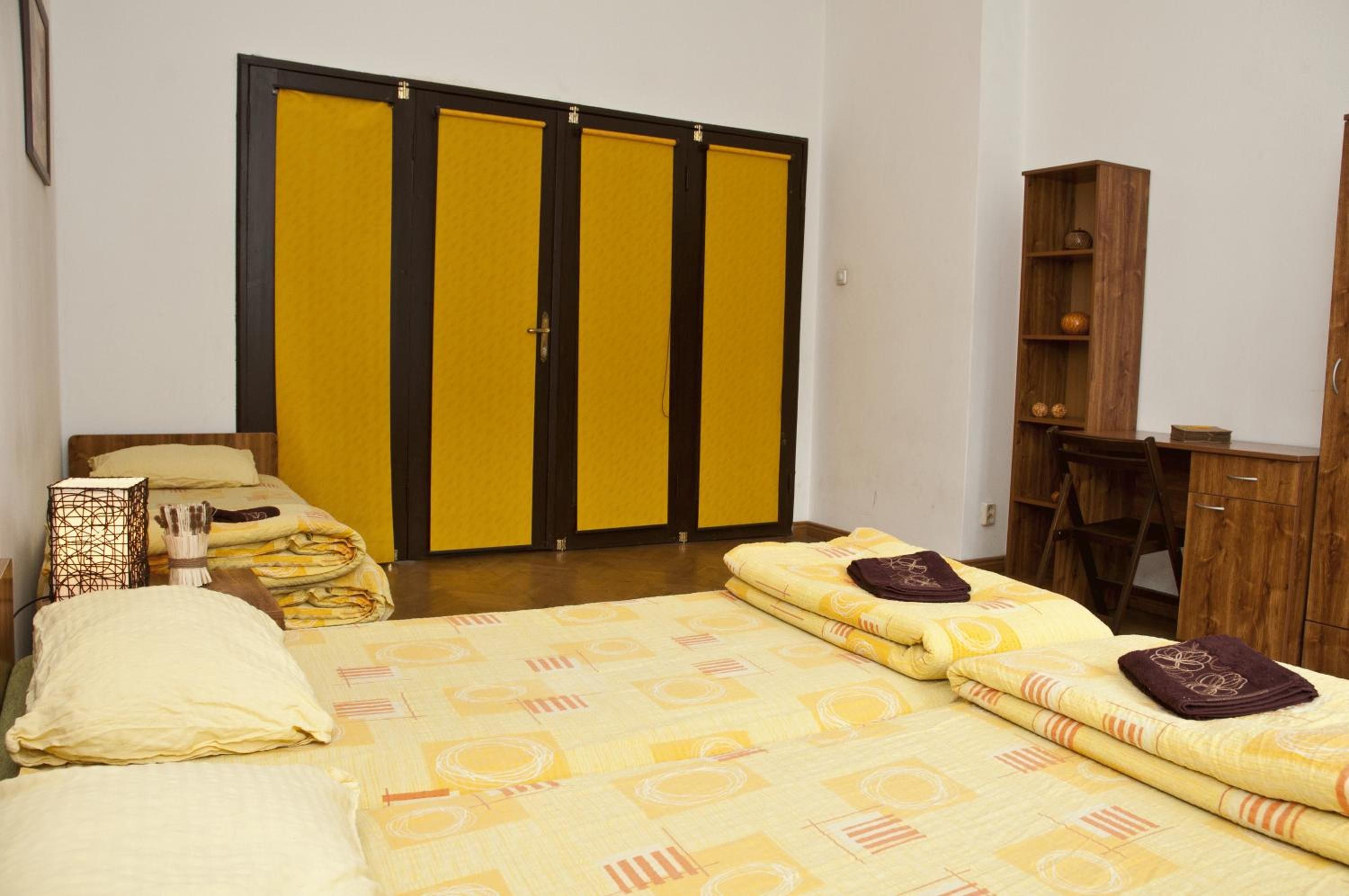 Un dormitorio con cama, armario, escritorio y silla.
