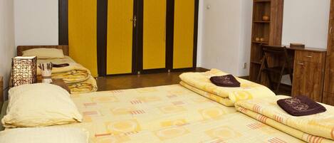 Un dormitorio con cama, armario, escritorio y silla.