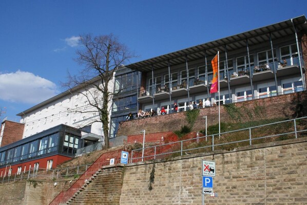 A multi-story building with a modern architectural design, featuring balconies and large windows.