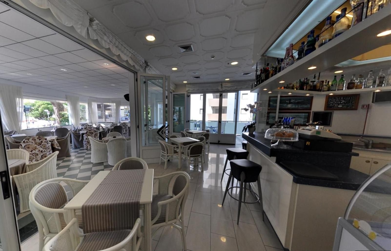 Un restaurant doté d’une terrasse, d’un bar et offrant une vue sur l’extérieur.