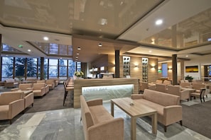 Un bar nella hall con posti a sedere e una reception.