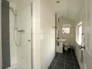 Ein Badezimmer mit Dusche, Toilette und Waschbecken.
