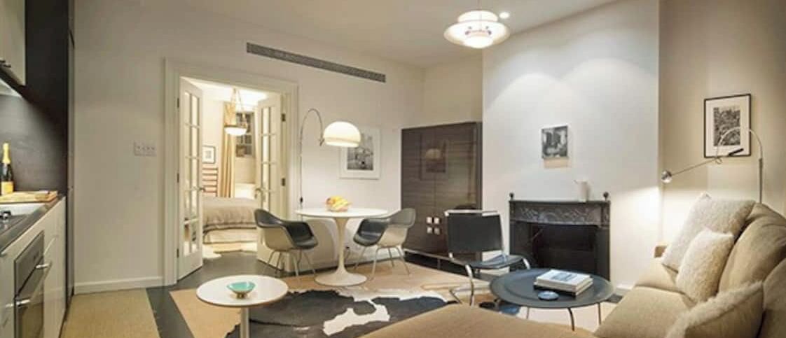 Un salon moderne avec une cheminée, un coin repas et une cuisine.