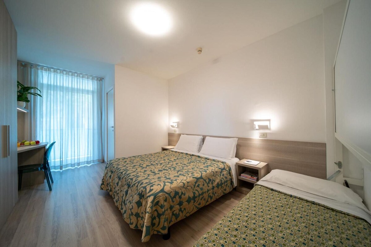 Una habitación de hotel con dos camas, un escritorio y una silla.