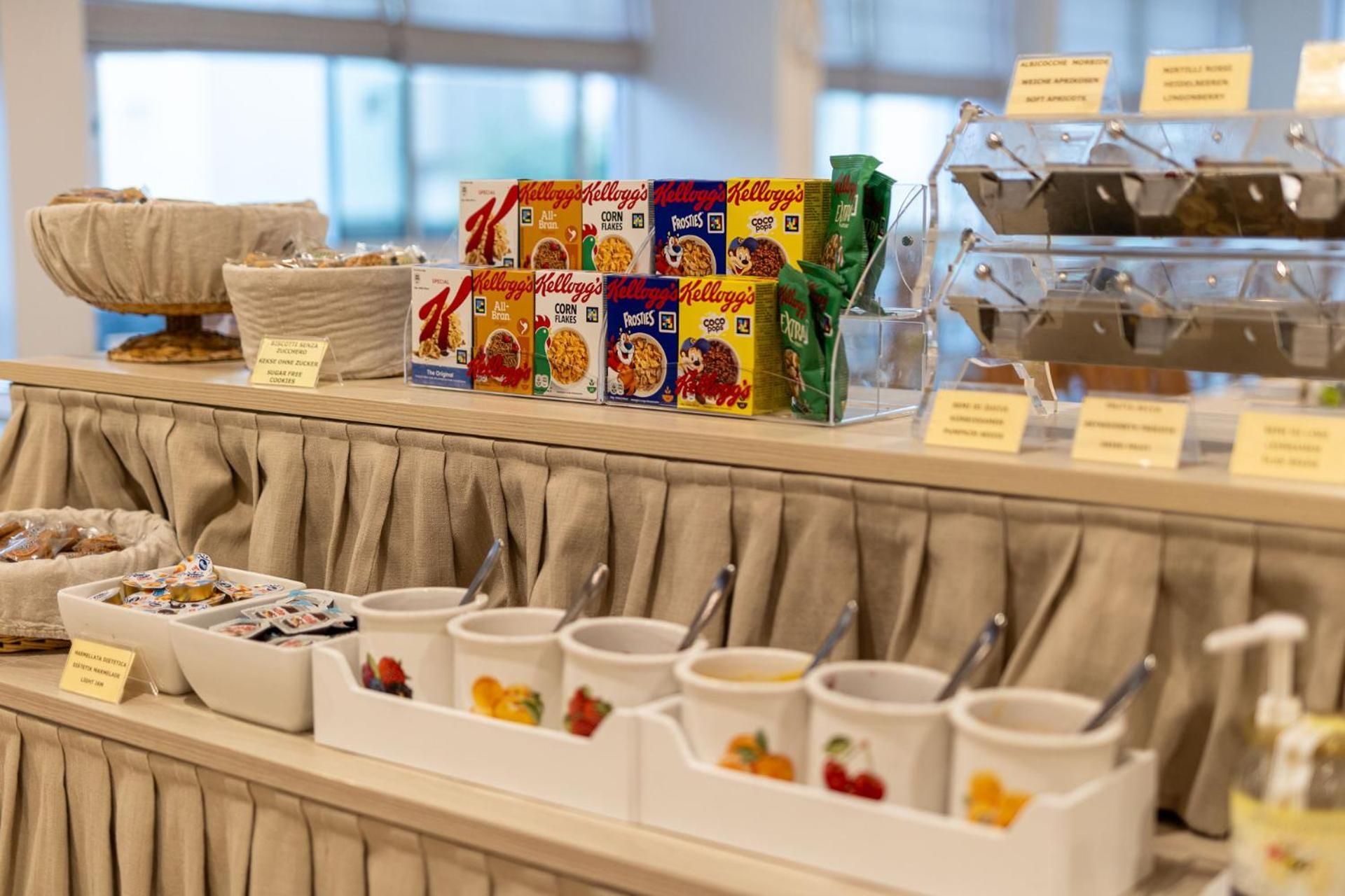 Buffet de café da manhã com diversos cereais e acompanhamentos.