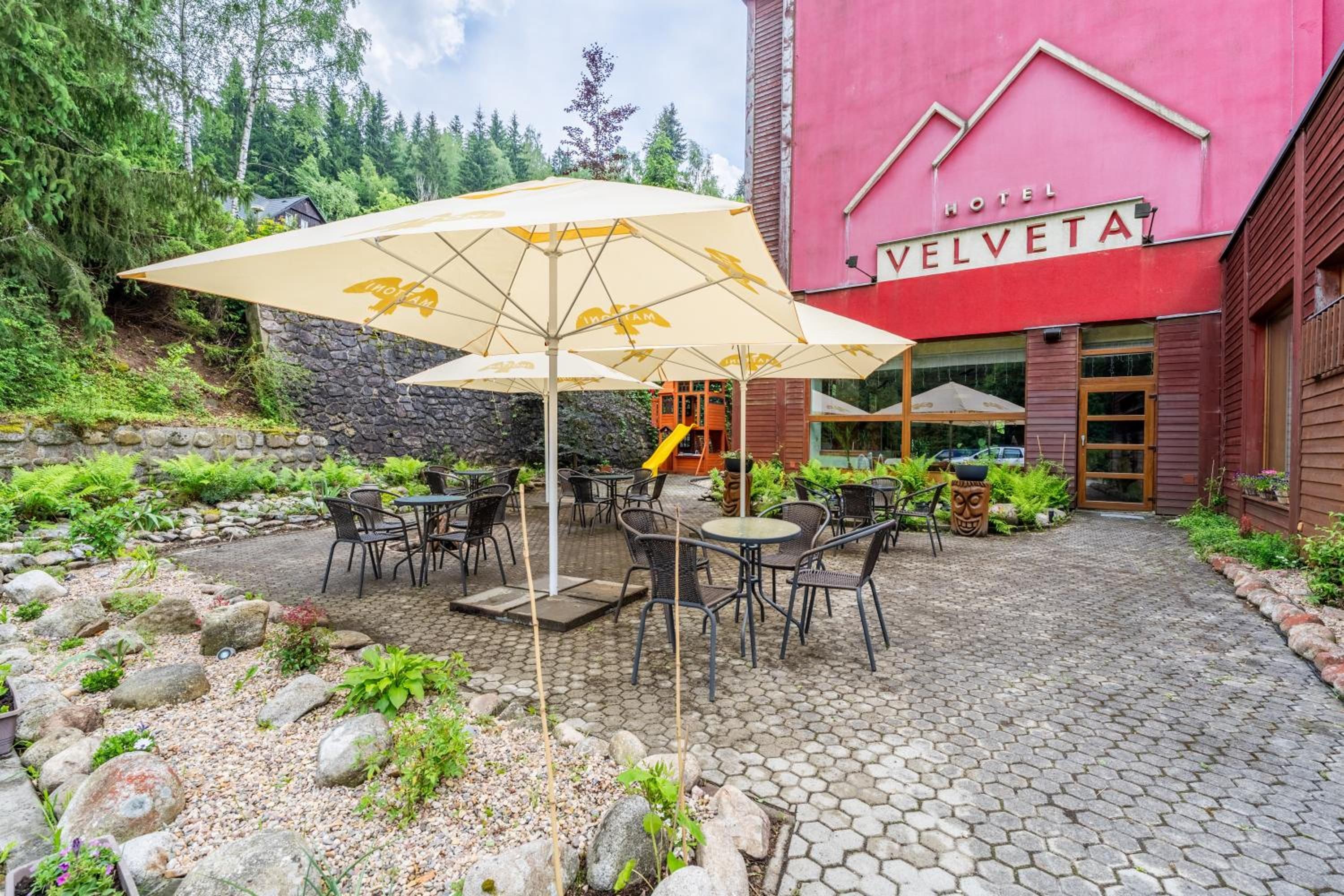 A hotel named 'Hotel Velveta' with outdoor seating and umbrellas.