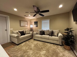 A living room with two sofas, a ceiling fan, a floor lamp, a window with blinds, and a potted plant. - Cozy 2-bedroom apt.  in peaceful Paris community 12 minutes from Oxford.  (Water Valley)