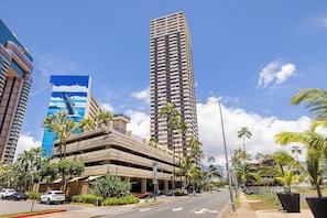 A multi-story parking garage with a clear sky and palm trees. - Waikiki Studio | Pool + Beach Gear | City Views (Honolulu)
