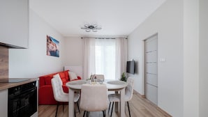 Eine moderne Küche mit eingebautem Backofen und einem Essbereich mit rundem Tisch und Stühlen.
