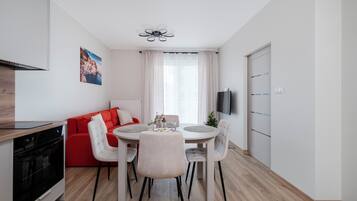 Eine moderne Küche mit eingebautem Backofen und einem Essbereich mit rundem Tisch und Stühlen.